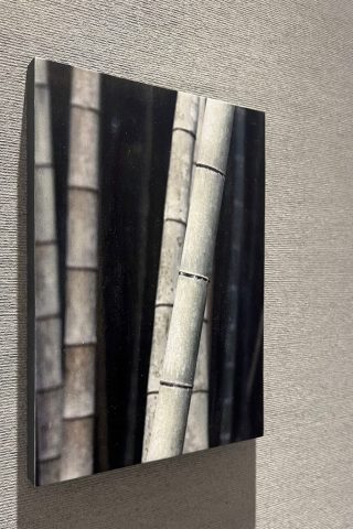 竹の質感をクローズアップしたモノトーンの木製プリントパネル。スパに設置された壁面装飾。