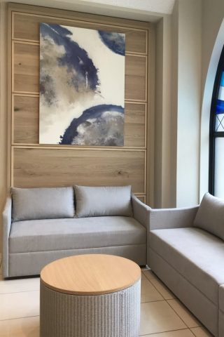 青とベージュを基調とした抽象画をキャンバスにプリントしたアートパネル。通路壁面に設置された壁面装飾。